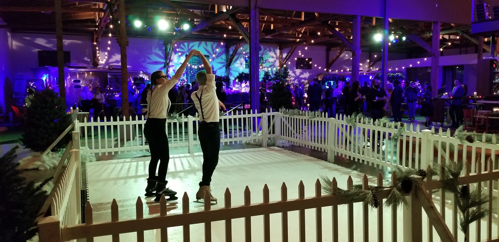 Guests skating beneath colorful event lighting