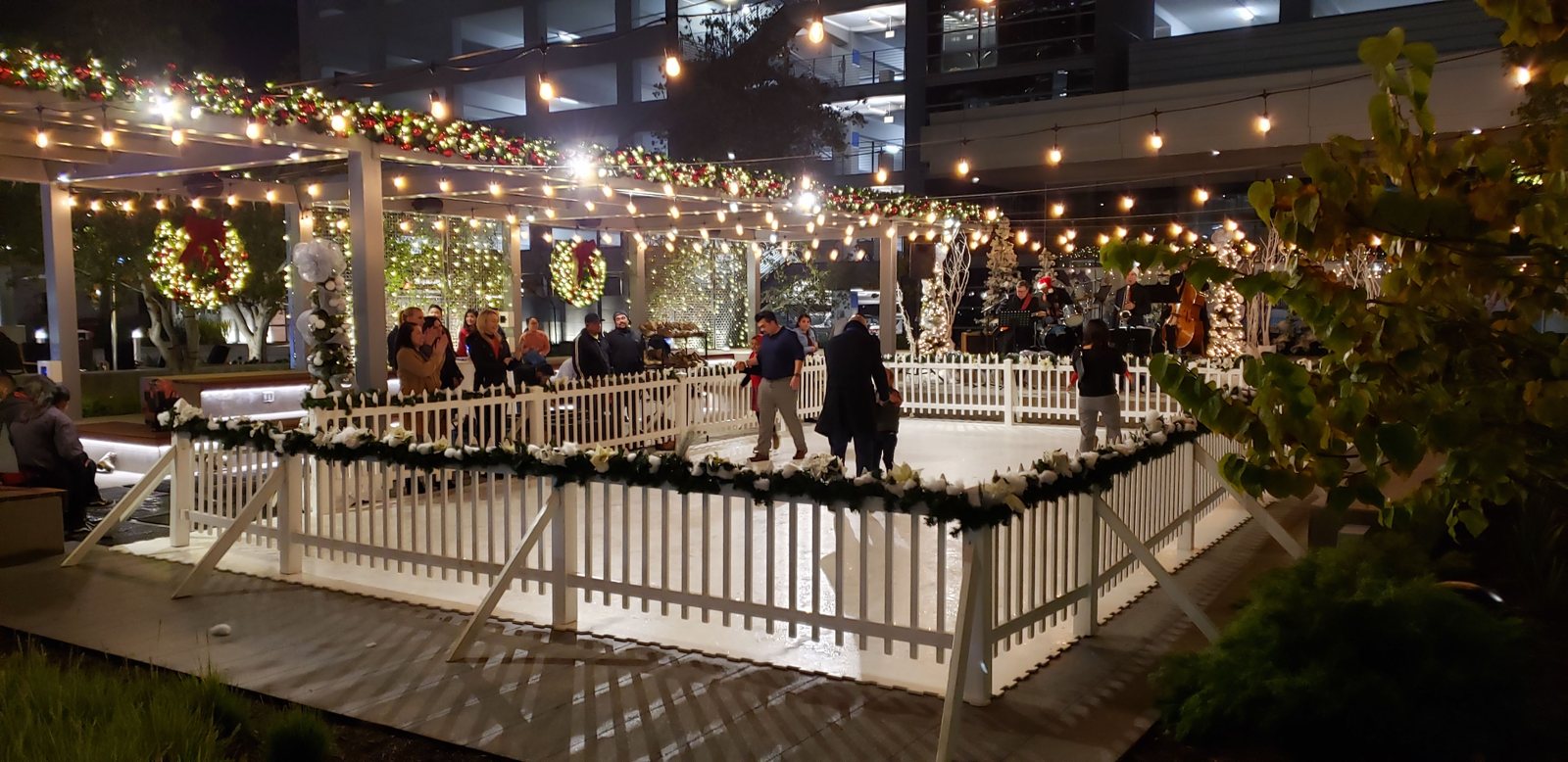 Evening skating rink beneath holiday string lights